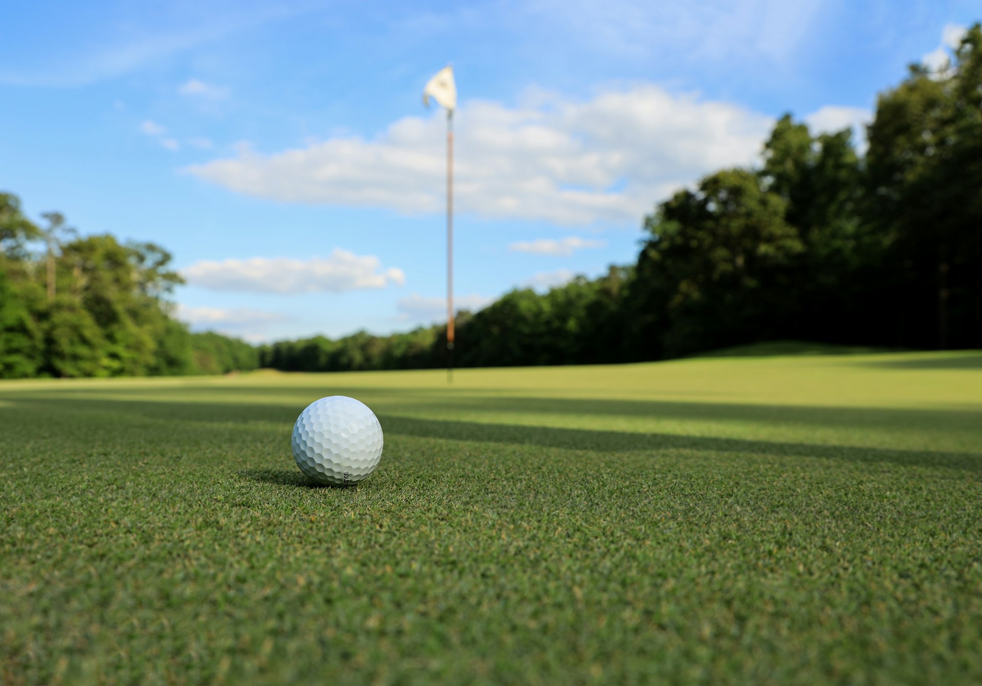 Golf ball next to pin on a UK golf course
